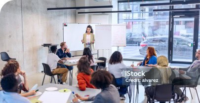 Workshop mit Teilnehmern und Moderatorin im Meetingraum.