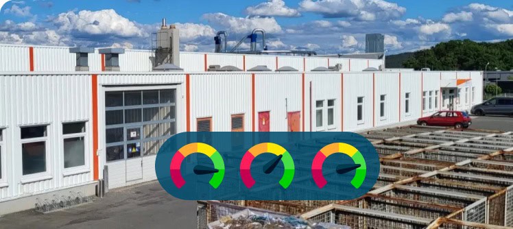 Industriegebäude mit Solaranlagen und Windkraftanlagen auf dem Dach.